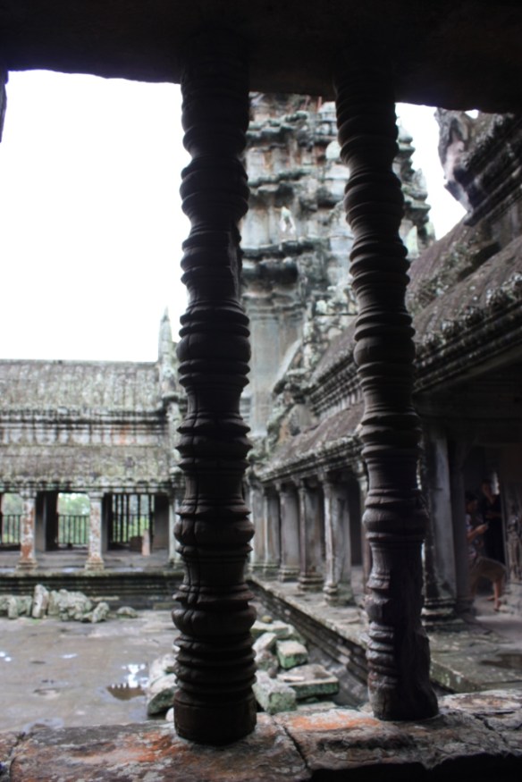 Courtyard as seen through a window with a couple pillars remaining