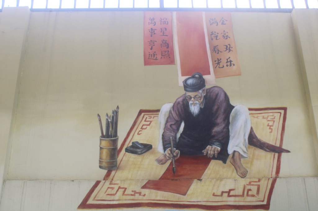 A mural of a calligrapher on a wall near the southeastern tip of West Lake (Hồ Tây) in Hanoi, Vietnam.