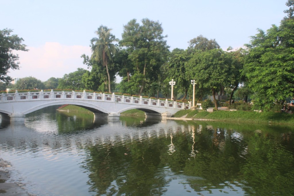 A bridge in Thống Nhất Park to an islet in the lake. Located in Hanoi, Vietnam.