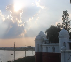 Setting sun over Rudrasagar Lake in Melaghar at the Neermahal Palace fringes clouds with sunlight.