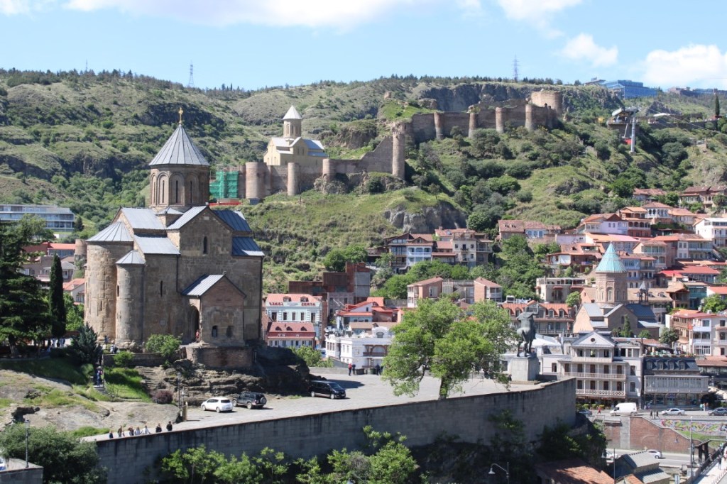 A photograph taken in Tbilisi, Georgia with Metekhi Church of the Nativity of the Mother of God in the fore (left) and Narikala Fortress in the background (probably from Queen Darejani Palace.)