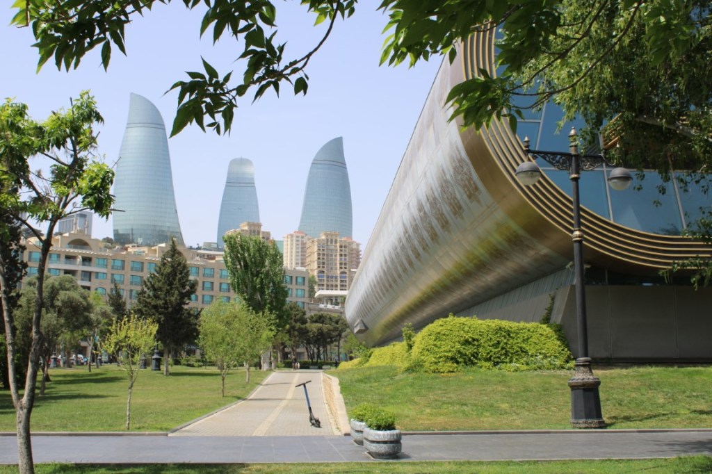 Photograph of the Carpet Museum (right fore) and the Flame Towers (left background) in Baku, Azerbaijan.