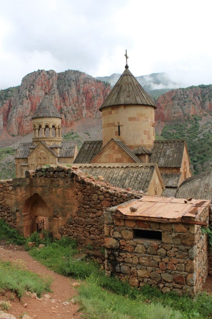 A photograph of Armenia's Noravank Monastery taken in portrait orientation.