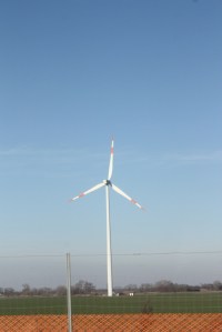 Photograph of a wind turbine under blue skies. Taken along the highway between Budapest and Vienna. 