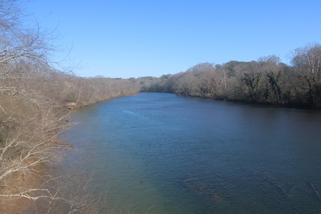 Photograph of the Chattahoochee River taken from a bridge such that it looks like the river just comes to an end. 