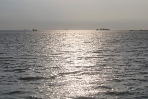 Photograph taken from the coast near Melaka, Malaysia of ships on a distant horizon. 