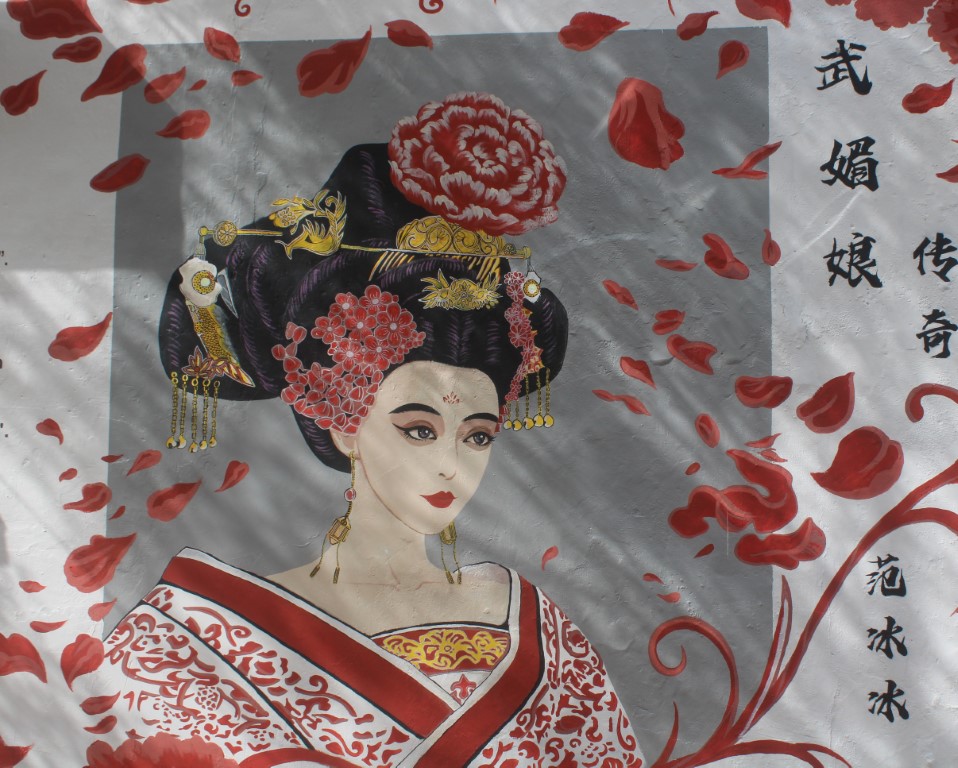 Photo of a mural of a lady showered in flower petals taken near the riverwalk in Melaka, Malaysia.