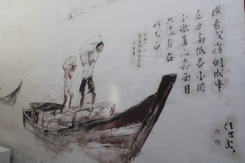 Photo of a mural of ferry laborers taken in Melaka, Malaysia.