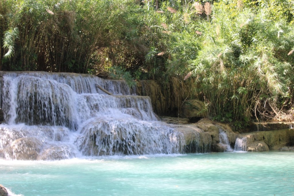 Photograph of a cascade and turquoise pool at Kuang Si waterfall in Laos.