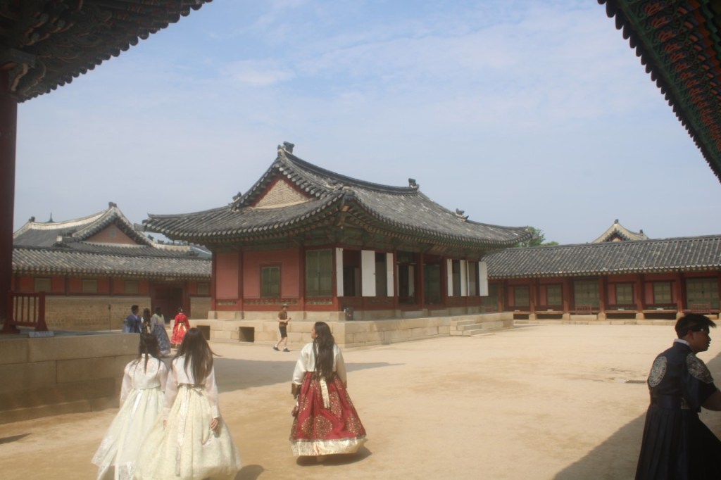 Photograph taken in Gyeongbokgung in Seoul, South Korea, featuring traditional Korean architecture and attire.