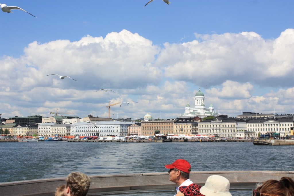Photograph of the Helsinki waterfront taken from the ferry to Suomenlinna with seagulls in tow.