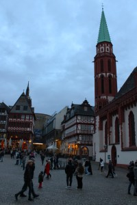 Photograph of Old St. Nicholas Church in Frankfurt am Main's town square at dusk.