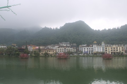 Photograph looking across Sa Pa Lake on a monsoon morning. Mountains in the background. 