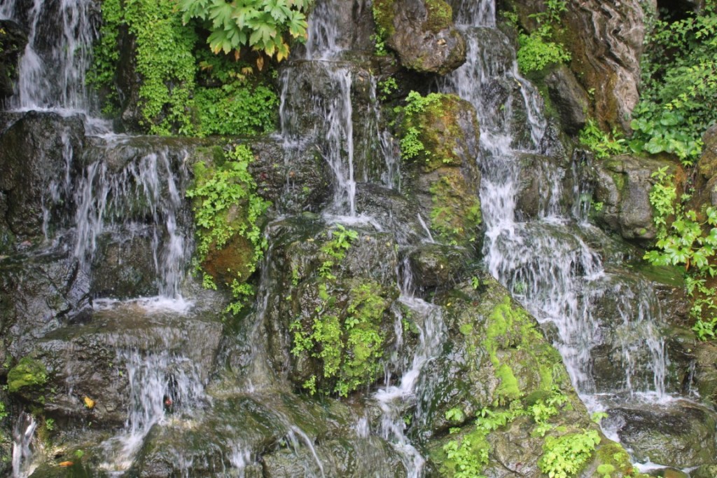 Photograph of water falling around mossy rocks. Taken on Seoul's Namsan greenspace.