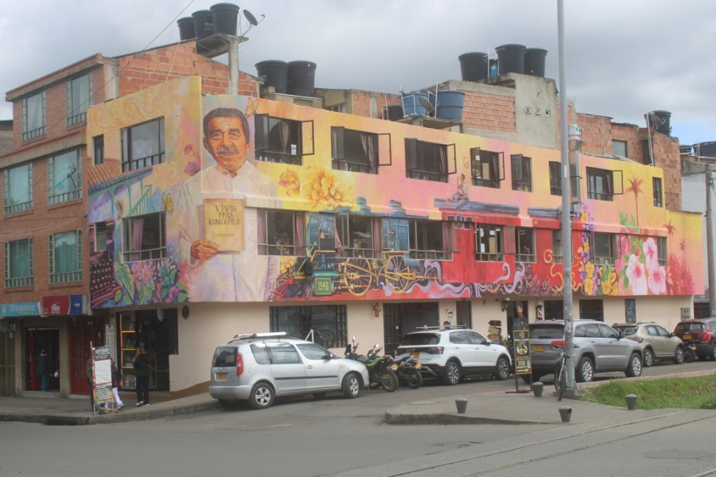Photograph of a colorful mural painted building next to the Cazique Zipa in Zipaquira, Colombia. 
