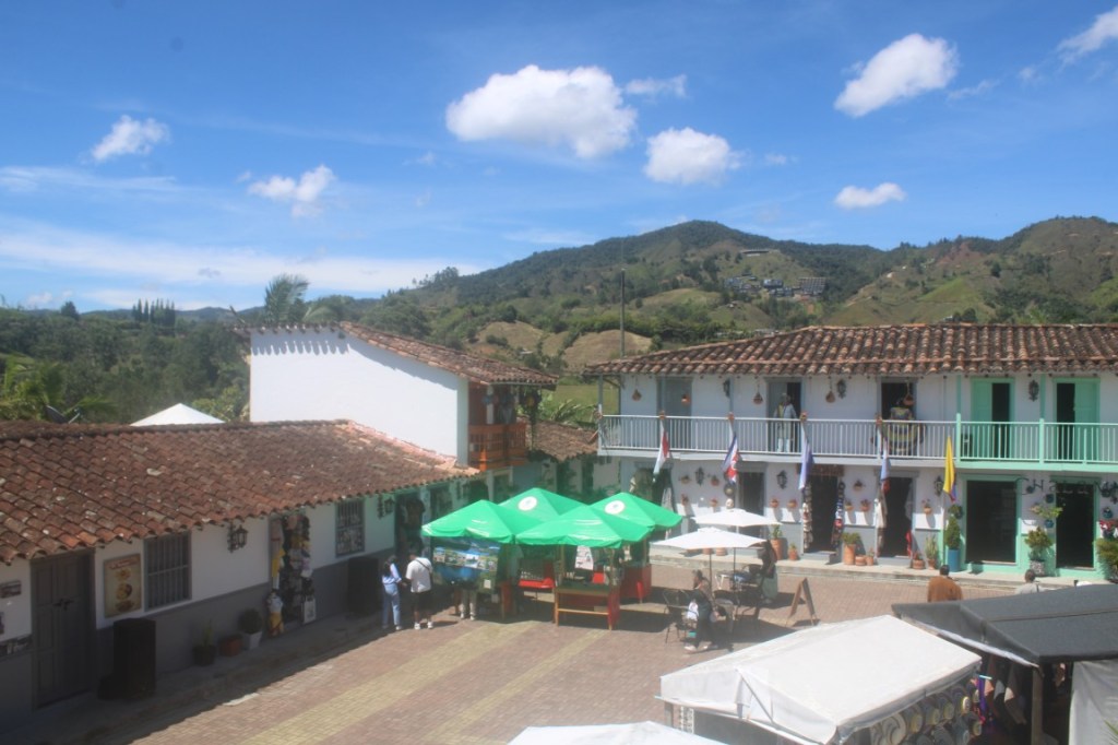 Photograph taken in the town square of Old Peñol with green hills as backdrop.