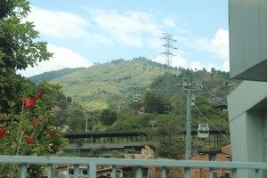 Photograph taken at the Oriente tram station (TA-1 line) of the H Cable Car line going up a green hill. 