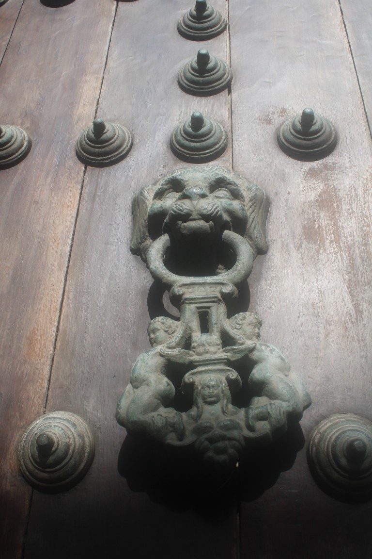 Photograph of a lionhead (or possibly doghead) doorknocker taken in Cartagena, Colombia.