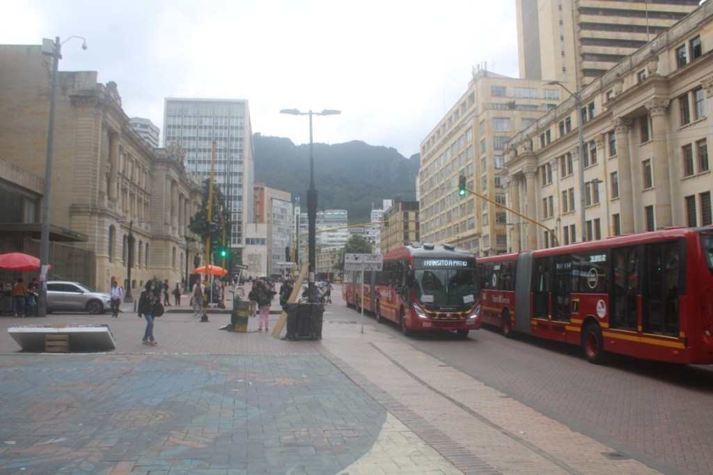 Photograph of the passing of two of Bogota's 3-sectional buses.