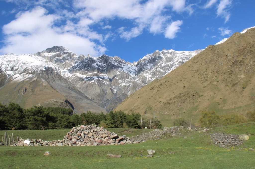 Photograph of snowcapped mountains taken in the area of Sno, Georgia in the Mtskheta-Mtianeti region. Taken near the stone sculptures of Merab Piranishvili.